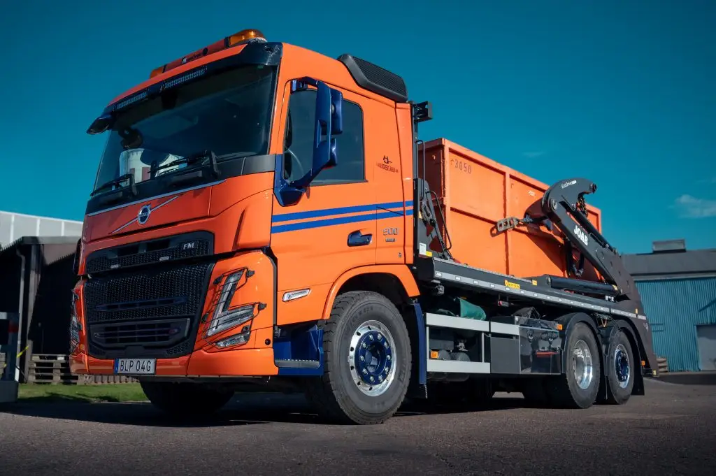 Orange MaserFrakt lastbil med container på flaket