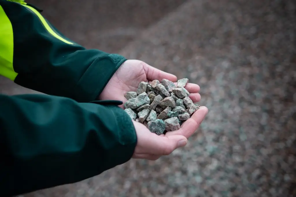 Två händer som håller i bergmaterial i MaserFrakts bergtäkt i Hofors