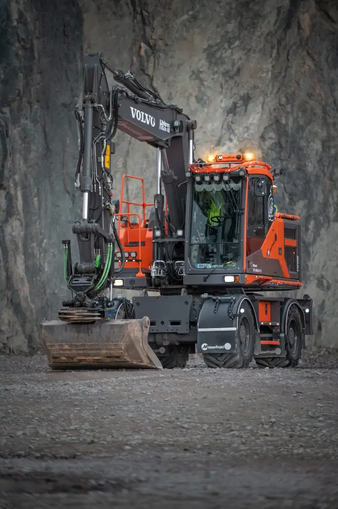 Orange MaserFrakt grävmaskin i en bergtäkt